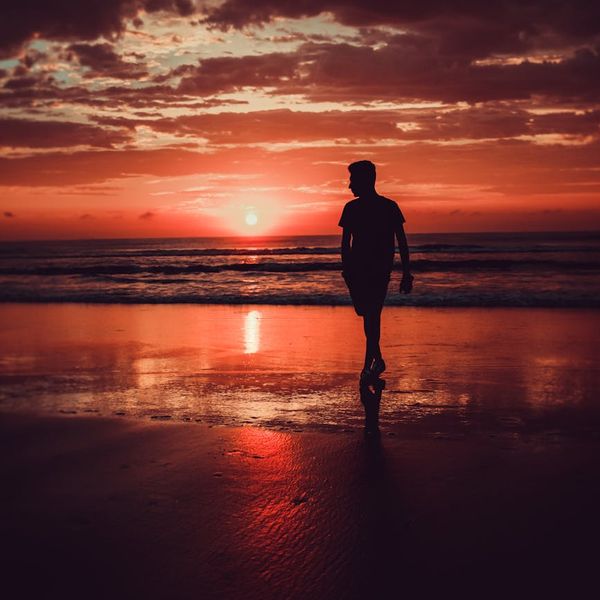 Silhouette of a person meditating during a beautiful sunrise.